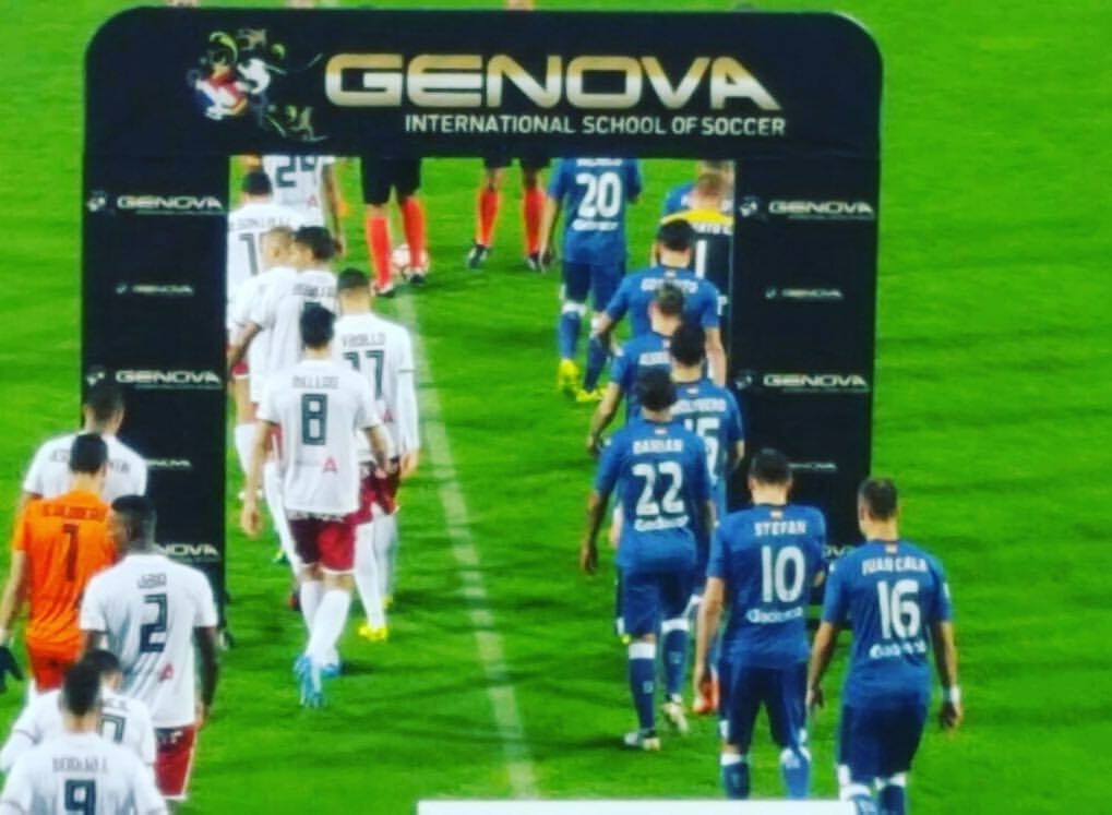 (La Liga players walking through Genova sign)
